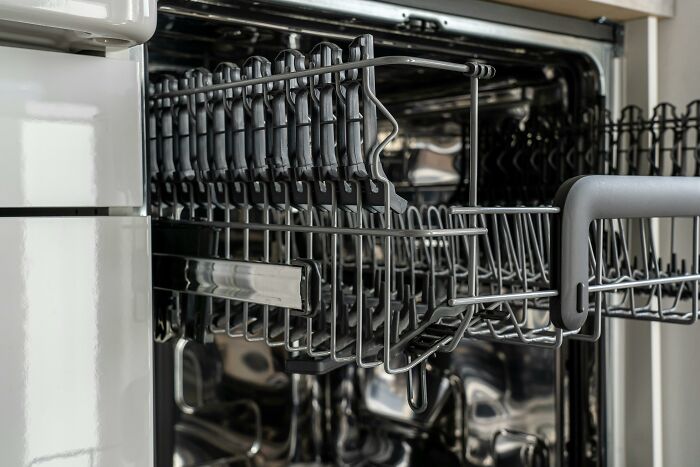 Open empty dishwasher rack inside a modern kitchen appliance reflecting calm and everyday household scenarios.