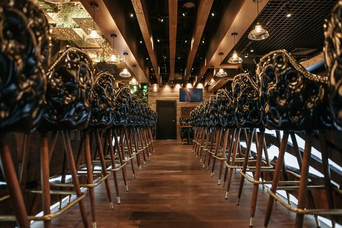 Upscale bar interior with ornate leather bar stools and warm lighting creating a calm and inviting atmosphere.