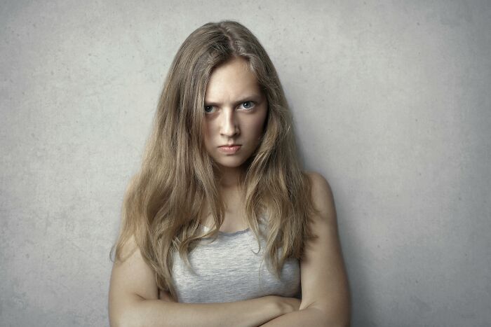 Young woman with long hair looking angry and tense, showing emotions related to staying calm or losing it in tough scenarios
