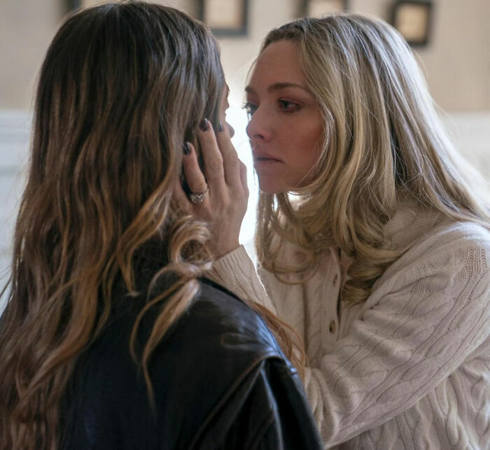 Two women in an intense moment indoors, with one gently holding the other's face in a dramatic scene. Two women in an intense moment indoors, with one gently holding the other's face in a dramatic scene.