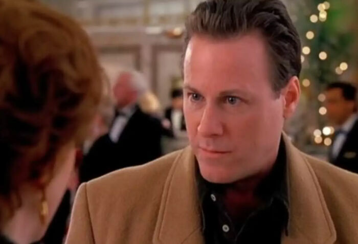 Man in brown coat talking to woman with blurred background capturing a scene related to Kevin’s dad’s job theory in Home Alone. Man in brown coat talking to woman with blurred background capturing a scene related to Kevin’s dad’s job theory in Home Alone.