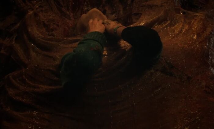 Dark scene from Stranger Things showing a character struggling inside a large creature, highlighting episode blunder exposed by fans.