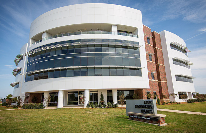 Modern university building with glass windows and a sign, related to student essay exposing trans instructor removal. Modern university building with glass windows and a sign, related to student essay exposing trans instructor removal.