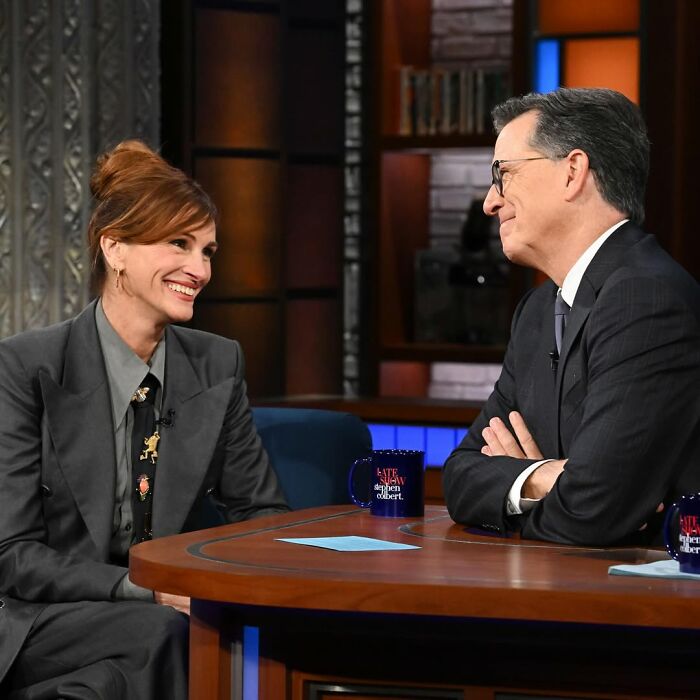 Two people share historical facts unknown until recently during a lively TV interview on a late-night talk show.