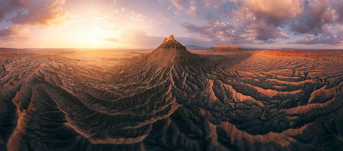 Vast desert landscape with rugged formations at sunset, showcasing best nature photography from international awards winners.