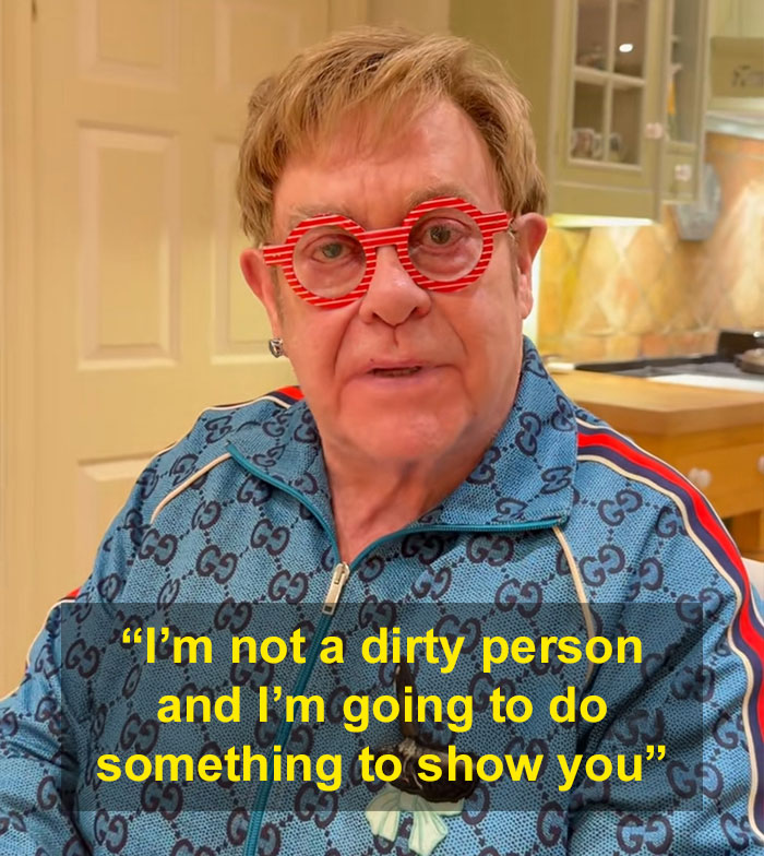 Elton John claps back at fans in his kitchen wearing red glasses and a blue patterned jacket. Elton John claps back at fans in his kitchen wearing red glasses and a blue patterned jacket.