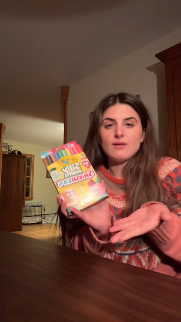 Woman holding dollar store craft markers, discussing child’s Angel Tree haul backlash in indoor home setting. Woman holding dollar store craft markers, discussing child’s Angel Tree haul backlash in indoor home setting.