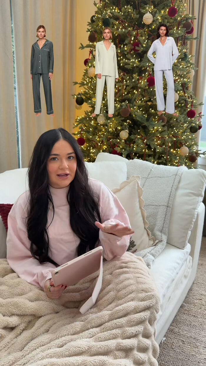 Woman sitting on couch with tablet near decorated Christmas tree showcasing cozy Christmas gifts and pajamas ideas.