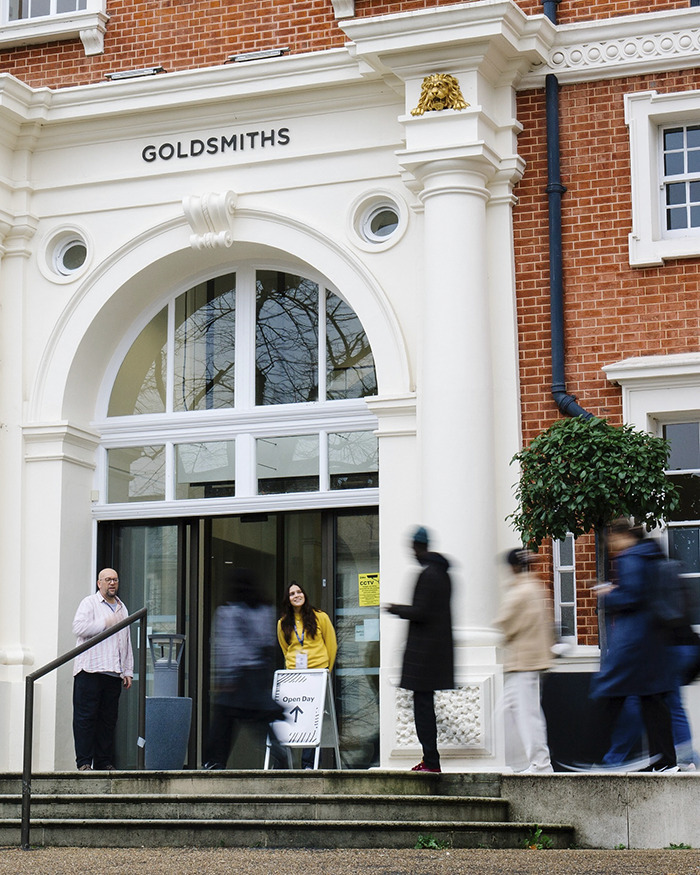 Entrance of Goldsmiths university building with students and staff outside during an open day event, highlighting wealthy US student behavior. Entrance of Goldsmiths university building with students and staff outside during an open day event, highlighting wealthy US student behavior.