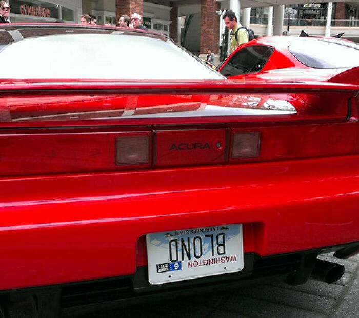 Red Acura sports car with a hilarious personalized upside-down license plate that made strangers do double takes.