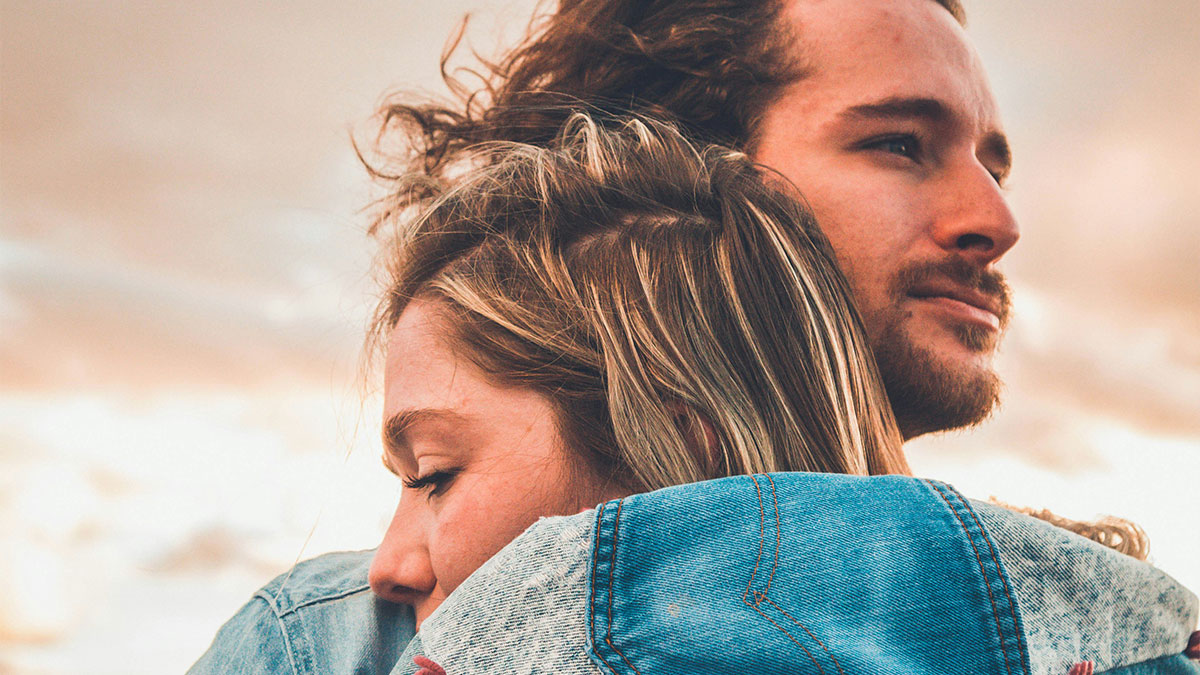 Young couple embracing outdoors, reflecting secrecy and complex emotions in a hidden romantic relationship situation.