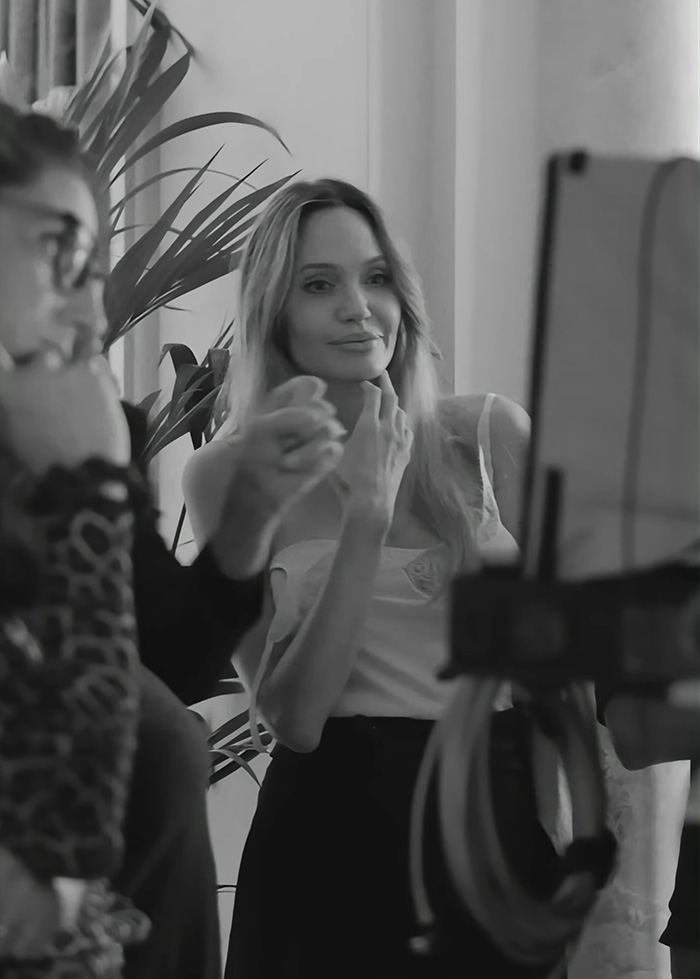 Angelina Jolie interacting on set, showcasing confidence while addressing trolls about her mastectomy scars.