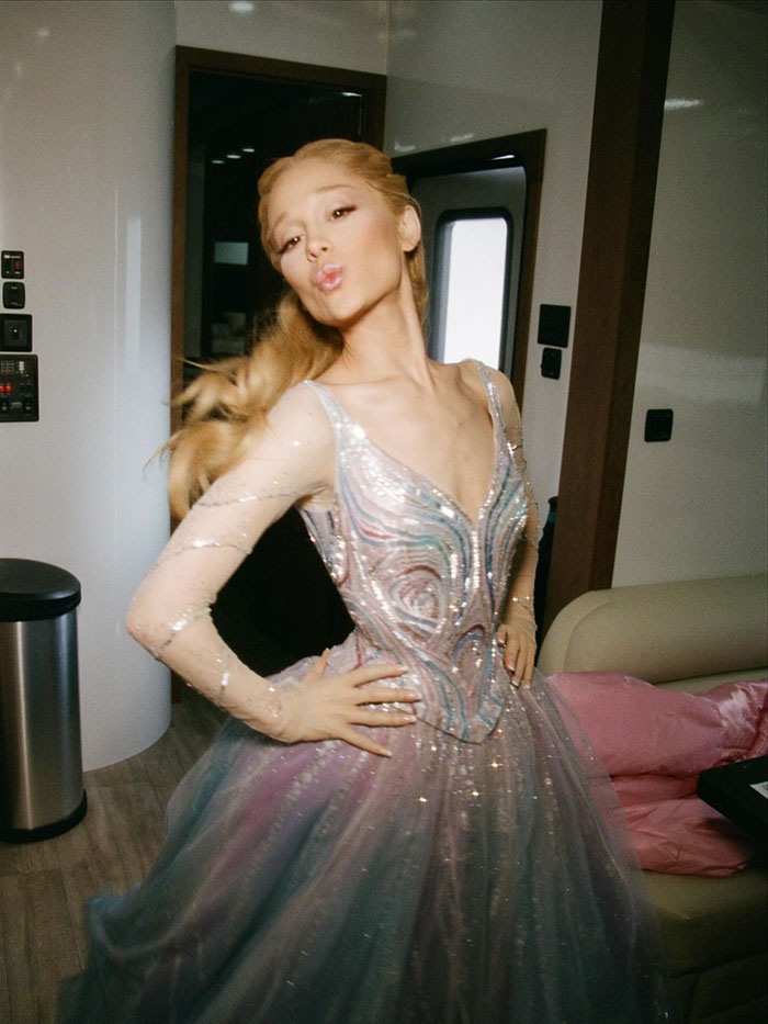 Ariana Grande posing confidently indoors, wearing a shimmering gown, highlighting body-shaming awareness and public reaction.