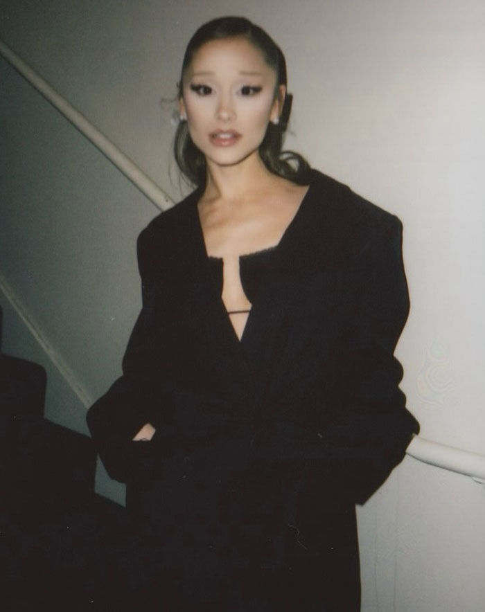 Ariana Grande wearing a black outfit posing indoors, with people noticing a bizarre detail in the photo shared by Rebel Wilson. Ariana Grande wearing a black outfit posing indoors, with people noticing a bizarre detail in the photo shared by Rebel Wilson.