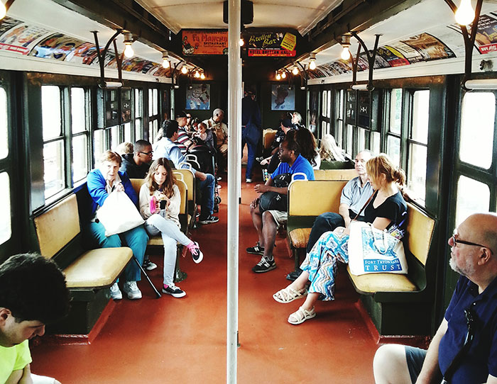 Passengers seated inside a vintage train carriage, illustrating a chaotic good moment with diverse people interacting.