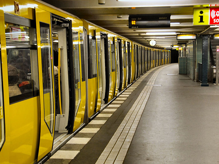 Yellow train stations platform with open doors, illustrating chaotic good moments shared by people in public transit scenes.
