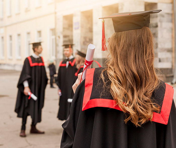 Group of graduates in caps and gowns holding diplomas, symbolizing chaotic good moments shared by 50 people.