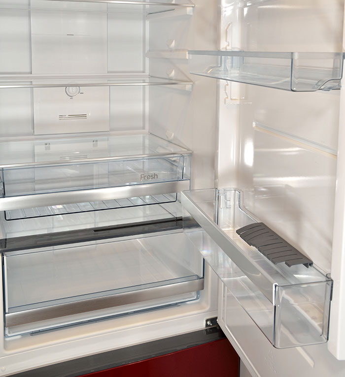 Empty refrigerator interior with clear shelves and fresh food compartment, illustrating a chaotic good moment.