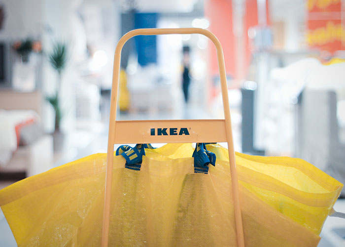 IKEA shopping cart with large yellow bags, revealing industry secrets customers rarely know from retail jobs.
