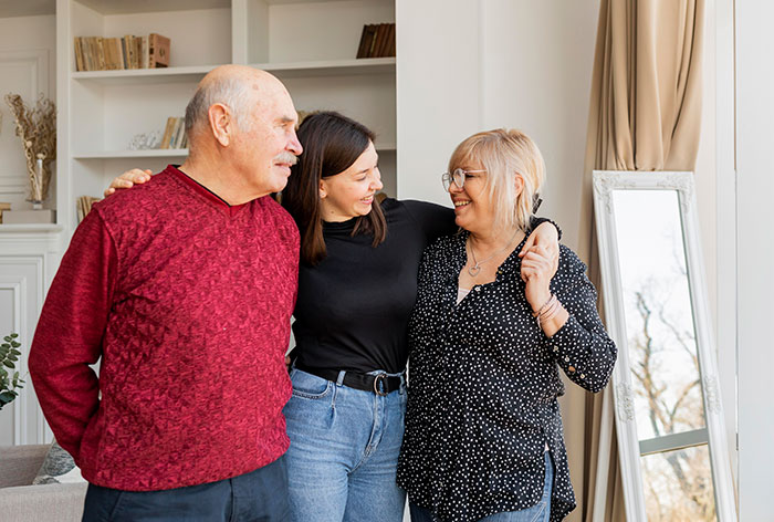 Adult woman sharing a moment with her parents at home, reflecting deep secrets people refuse to reveal to their parents.