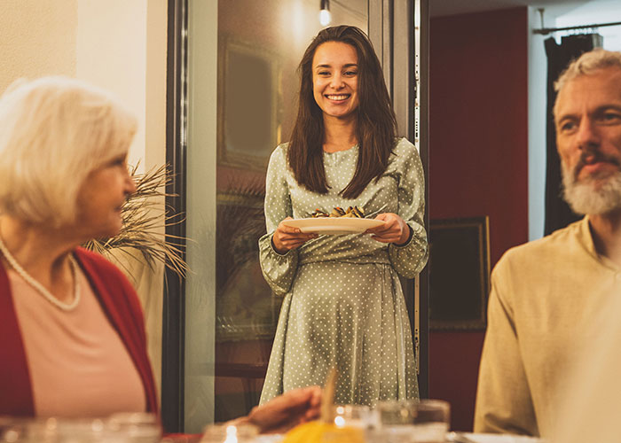 Young woman rethinking her engagement during tense holiday dinner after fiancé’s lie about her family causes conflict.