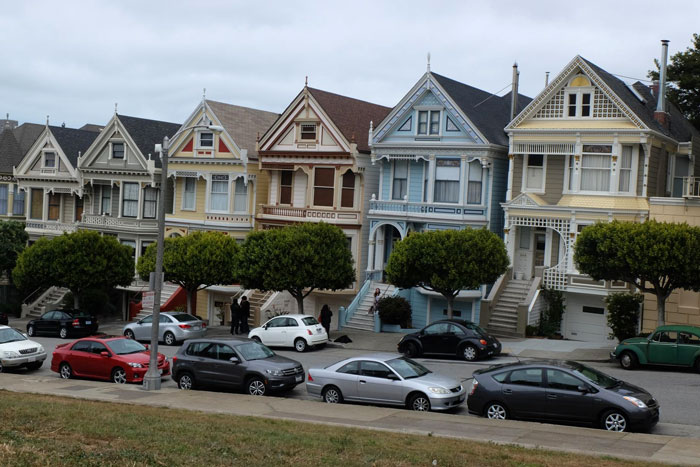 Victorian houses with cars parked along street, some blocking fire hydrant and driveway in residential neighborhood. Victorian houses with cars parked along street, some blocking fire hydrant and driveway in residential neighborhood.