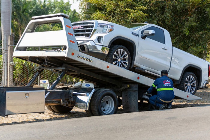 Tow truck loading a white pickup truck after blocking a fire hydrant and driveway in a residential area. Tow truck loading a white pickup truck after blocking a fire hydrant and driveway in a residential area.