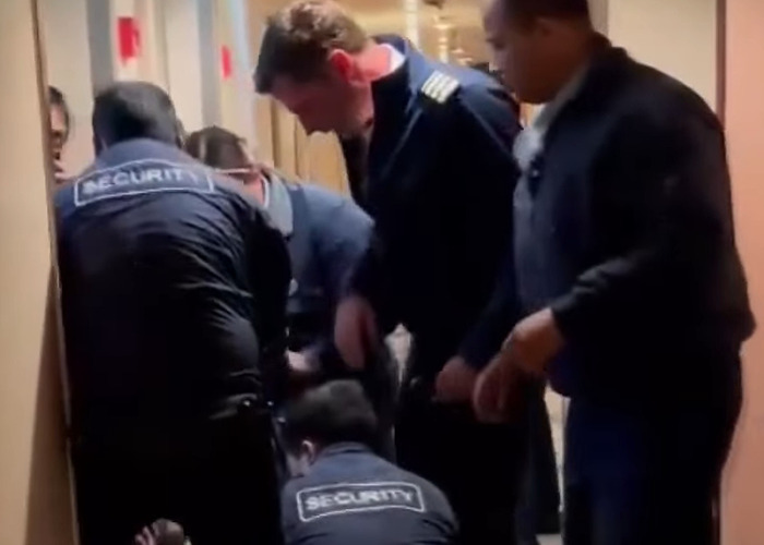 Security and crew members handling the cruise passenger's body after fatal overconsumption of drinks on board. Security and crew members handling the cruise passenger's body after fatal overconsumption of drinks on board.