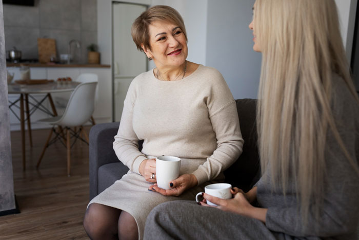 Two women having a heartfelt conversation over coffee, discussing a breaking up ultimatum over ring in a cozy living room. Two women having a heartfelt conversation over coffee, discussing a breaking up ultimatum over ring in a cozy living room.