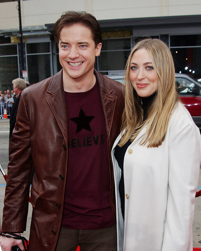 Brendan Fraser smiling at a public event, wearing a brown leather jacket, highlighting his career after Oscar victory.