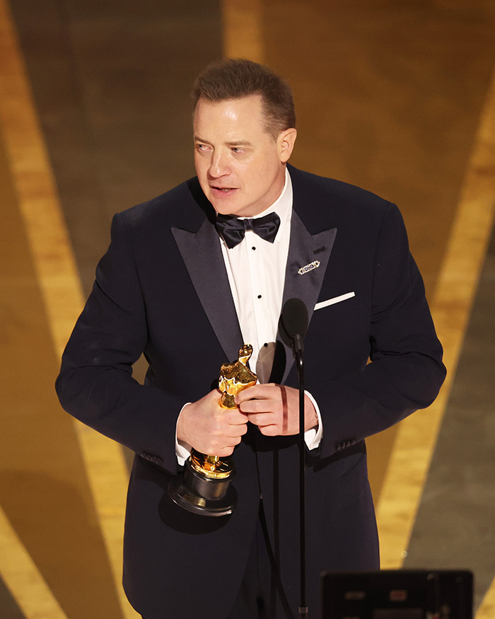 Brendan Fraser in a tuxedo holding an Oscar, sharing the heartbreaking truth about his career after Oscar victory.