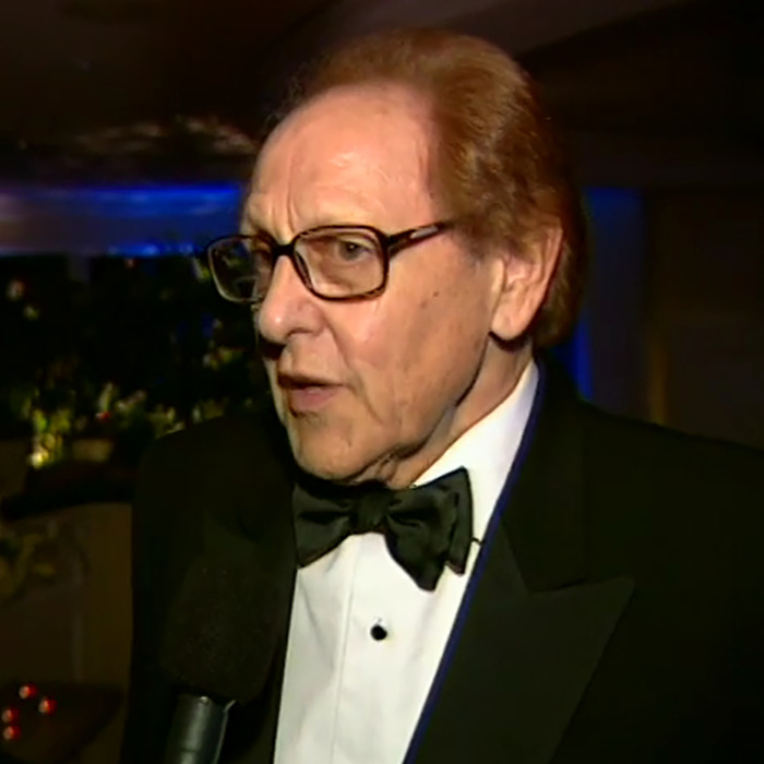 Man in a tuxedo and glasses speaking into a microphone about Brendan Fraser’s career after Oscar victory. Man in a tuxedo and glasses speaking into a microphone about Brendan Fraser’s career after Oscar victory.