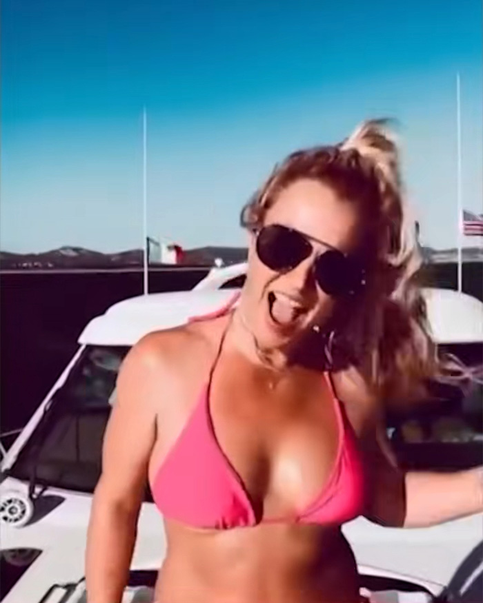 Britney Spears in pink bikini on a yacht wearing sunglasses, enjoying a sunny day with ocean and distant hills in the background. Britney Spears in pink bikini on a yacht wearing sunglasses, enjoying a sunny day with ocean and distant hills in the background.