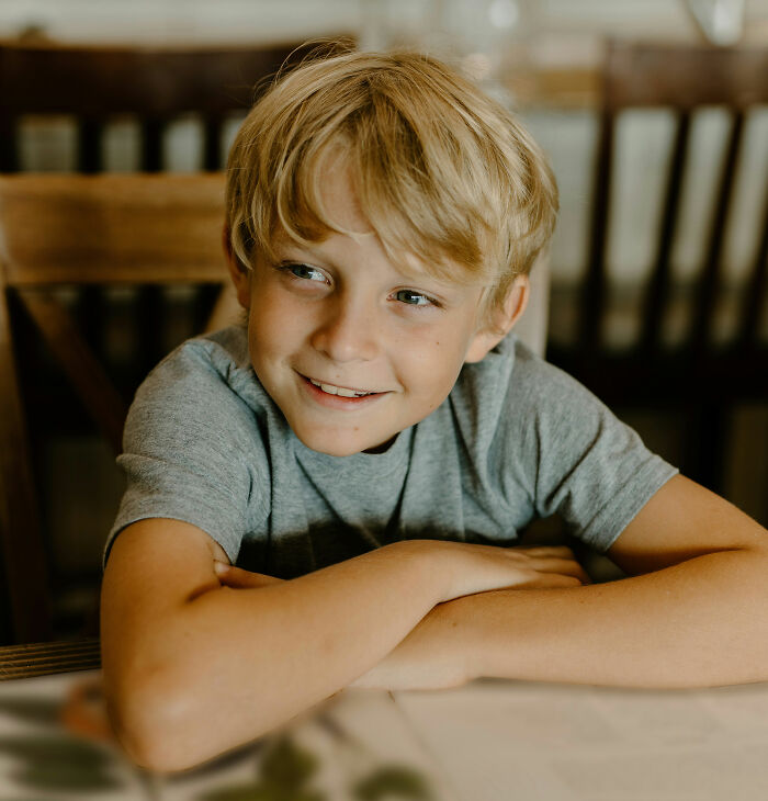 Blond young boy smiling and leaning on a table, representing bizarre and unbelievable names people actually gave their children.