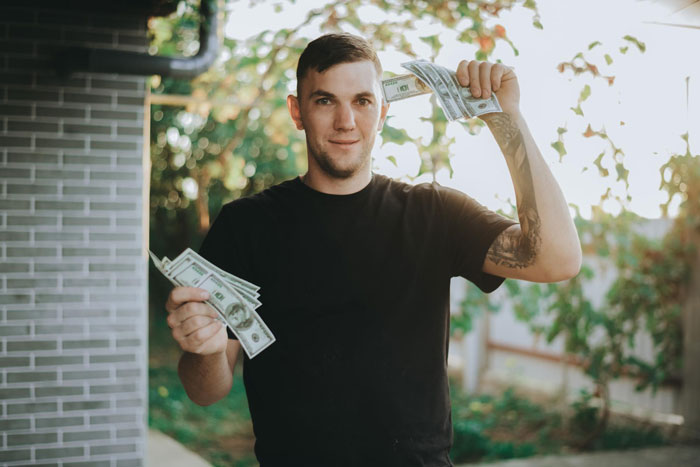 Young man outdoors holding cash in both hands, brother-money-wife-family Young man outdoors holding cash in both hands, brother-money-wife-family