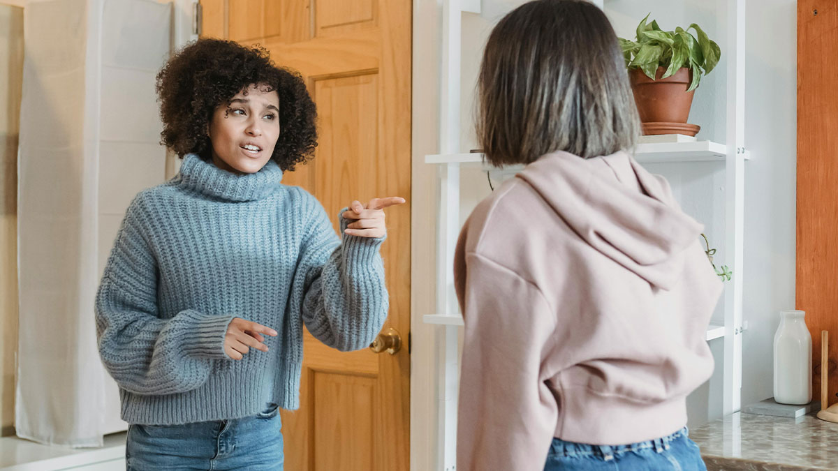 Woman talking to another woman indoors, depicting family visit and wife complaining about the stay.