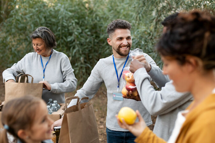 Group of volunteers sharing food and packing bags outdoors, illustrating small decisions leading to unexpected life-altering consequences.