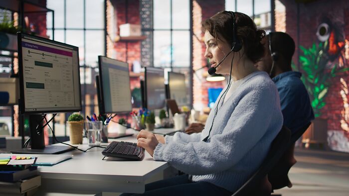 Customer service representatives working at computers in a modern office, illustrating fastest job quitting stories.