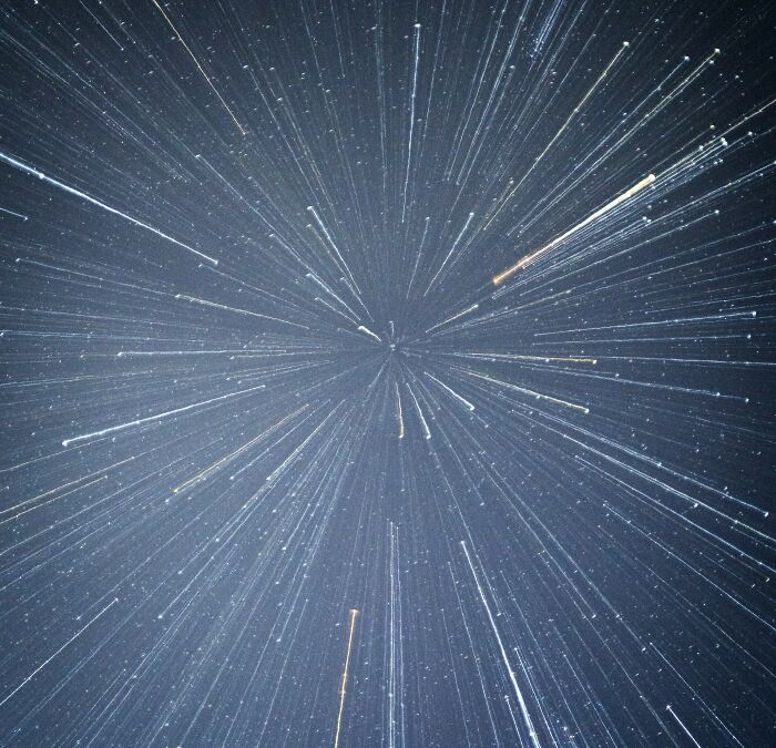 Star trails radiating in a night sky, illustrating cosmic mysteries that we aren’t getting closer to solving.
