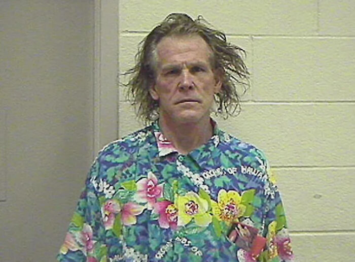 Infamous celebrity mugshot of a man in a colorful Hawaiian shirt after being arrested.