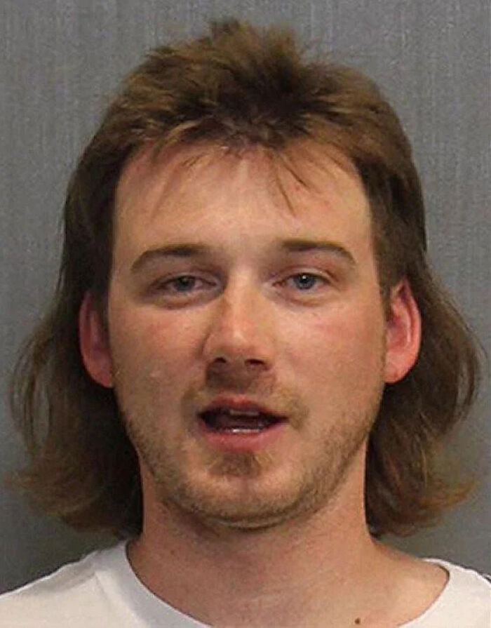 Mugshot of a young man with a mullet hairstyle, part of infamous celebrity mugshots collection for arrests.