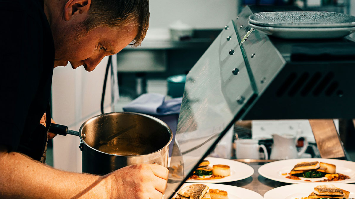 Chef carefully plating dishes in a professional kitchen, capturing moments that made chefs stop cooking professionally.