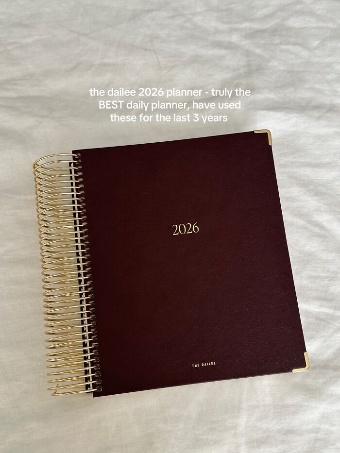Maroon 2026 daily planner with gold spiral binding and corner accents, praised as a top Christmas gift recommendation.
