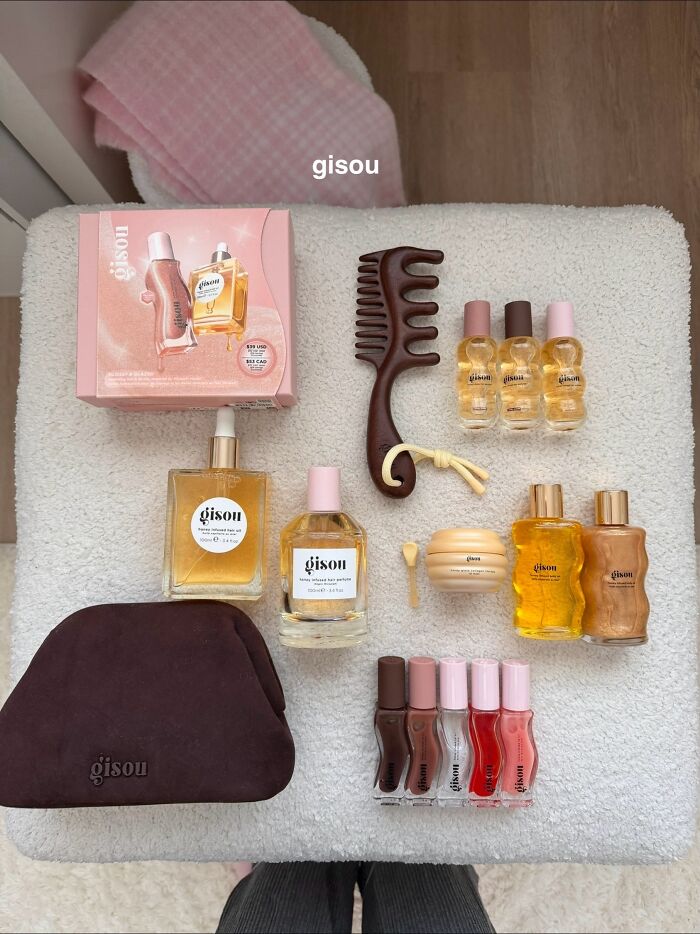 Flat lay of Gisou haircare products and accessories arranged on a white textured surface, highlighting popular Christmas gifts.