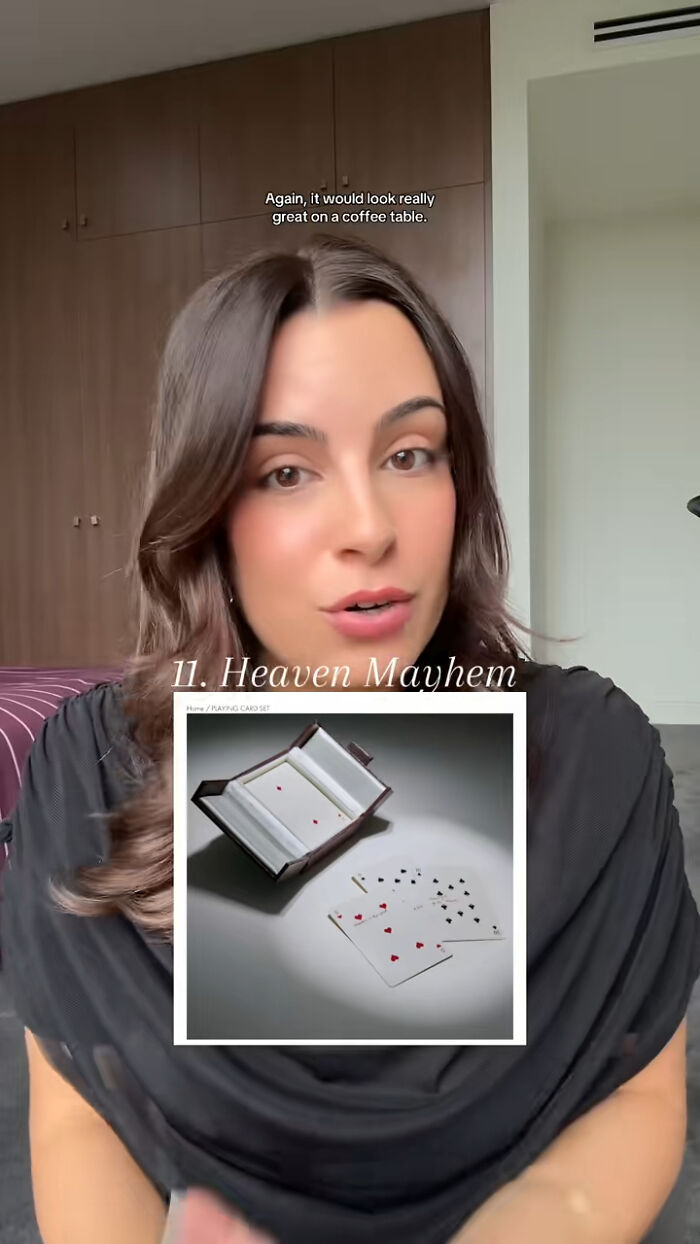 Woman recommending Christmas gifts, holding a Heaven Mayhem playing card set, sharing top gift ideas and favorites.