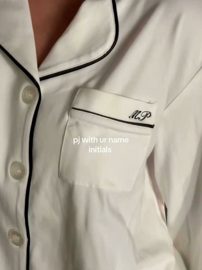White pajamas with black trim and personalized initials embroidered on the pocket, a top Christmas gift recommendation.