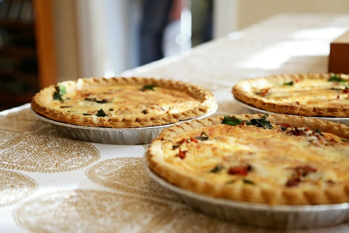 Three homemade savory pies on a festive table, capturing the spirit of work Christmas parties and wild stories.