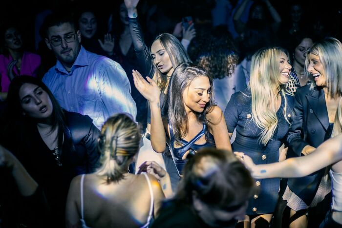 A lively crowd dancing and socializing at a wild work Christmas party with festive and energetic atmosphere.