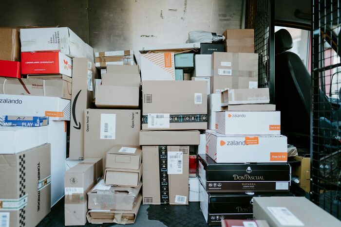 Stacked parcels and packages inside a postal delivery vehicle illustrating the daily realities of being a postal worker.