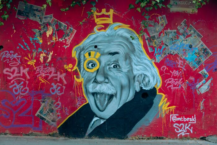 Street art mural of Albert Einstein with colorful graffiti, illustrating people share historical facts unknown until recently.
